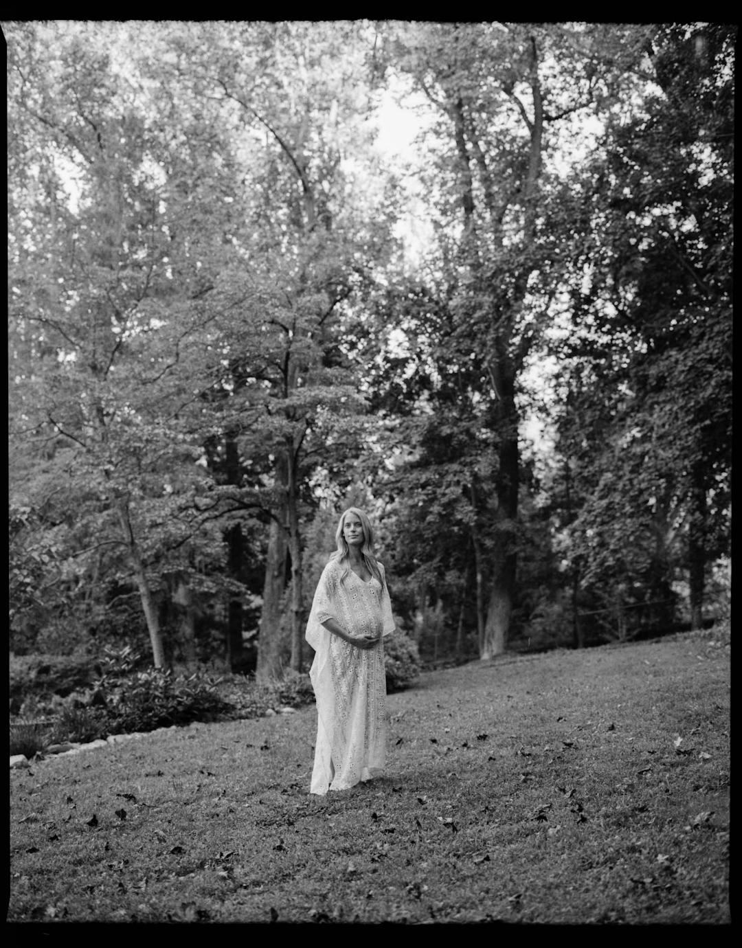 black and white medium format maternity portrait of woman in white dress 