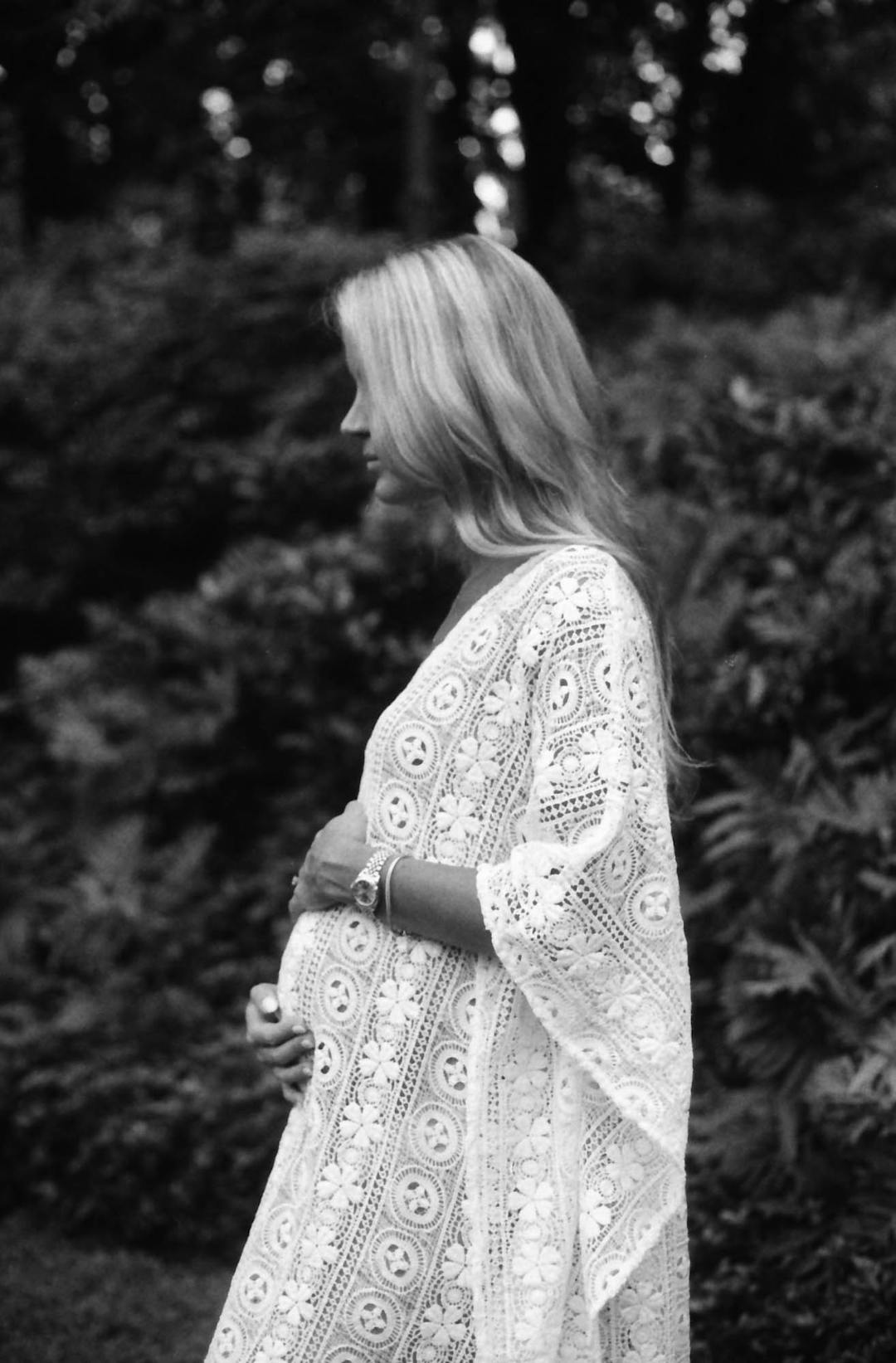 black and white medium format maternity portrait in profile of woman in white dress 