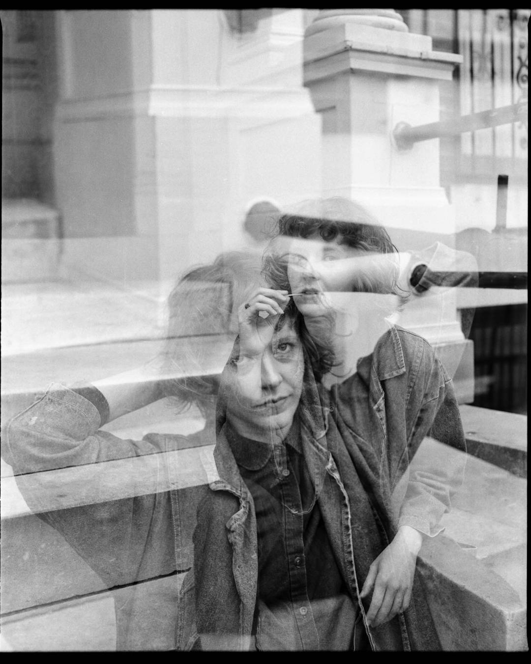 black and white medium format double exposure of woman sitting outside on steps