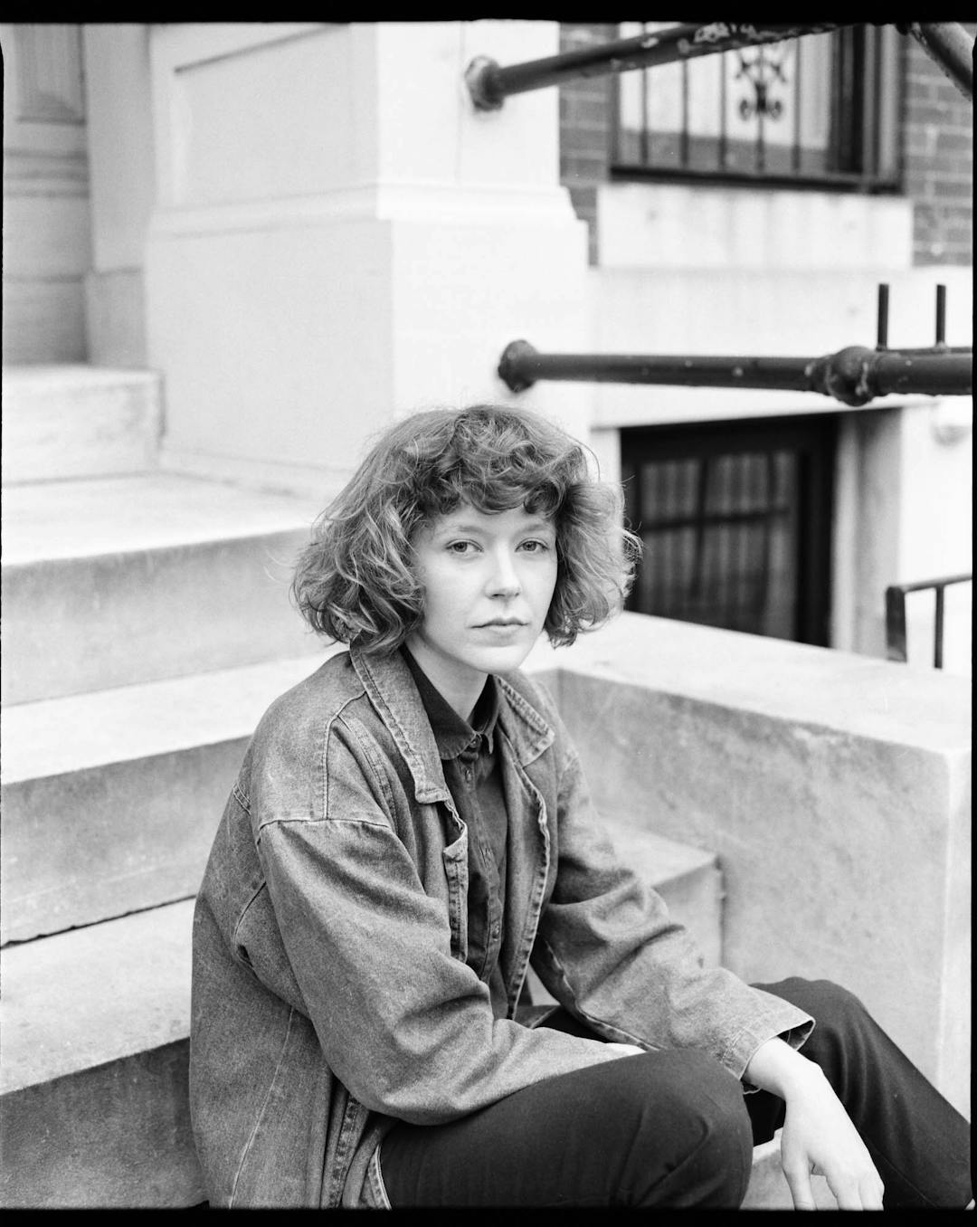 black and white medium format portrait of woman sitting outside on steps 