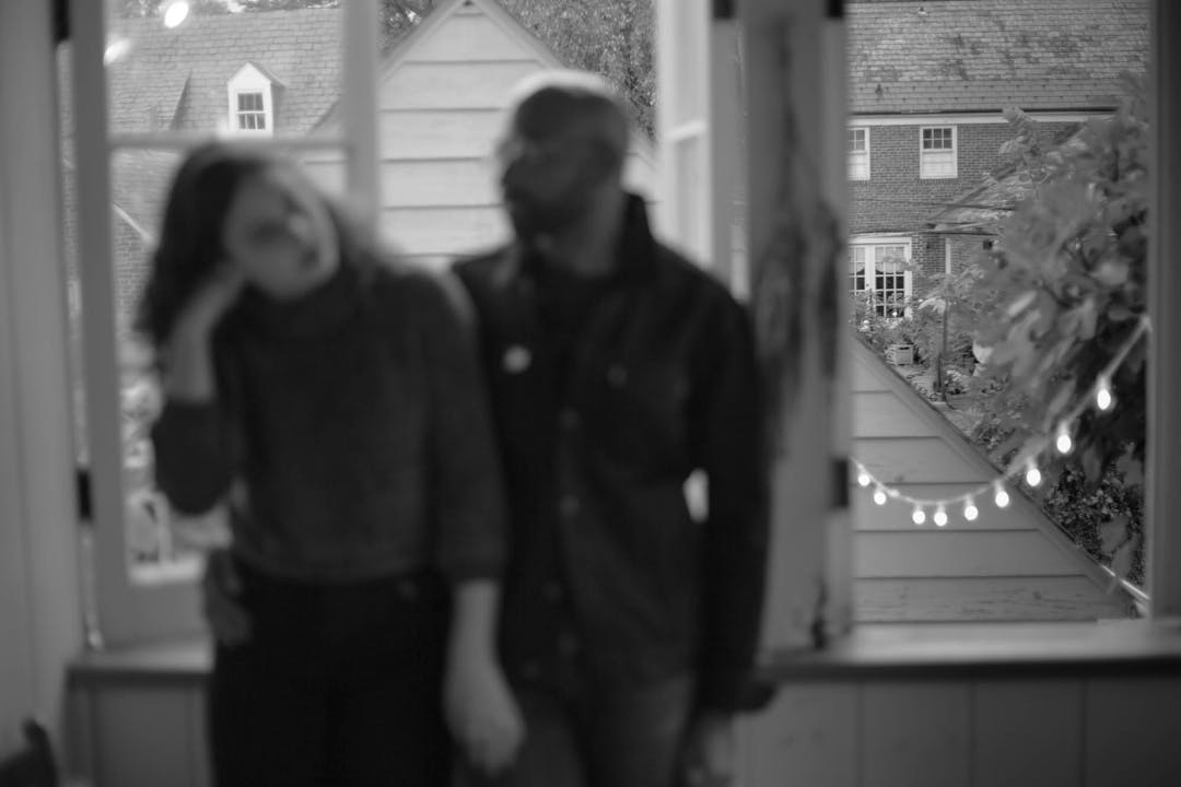blurry black and white photo of couple by window