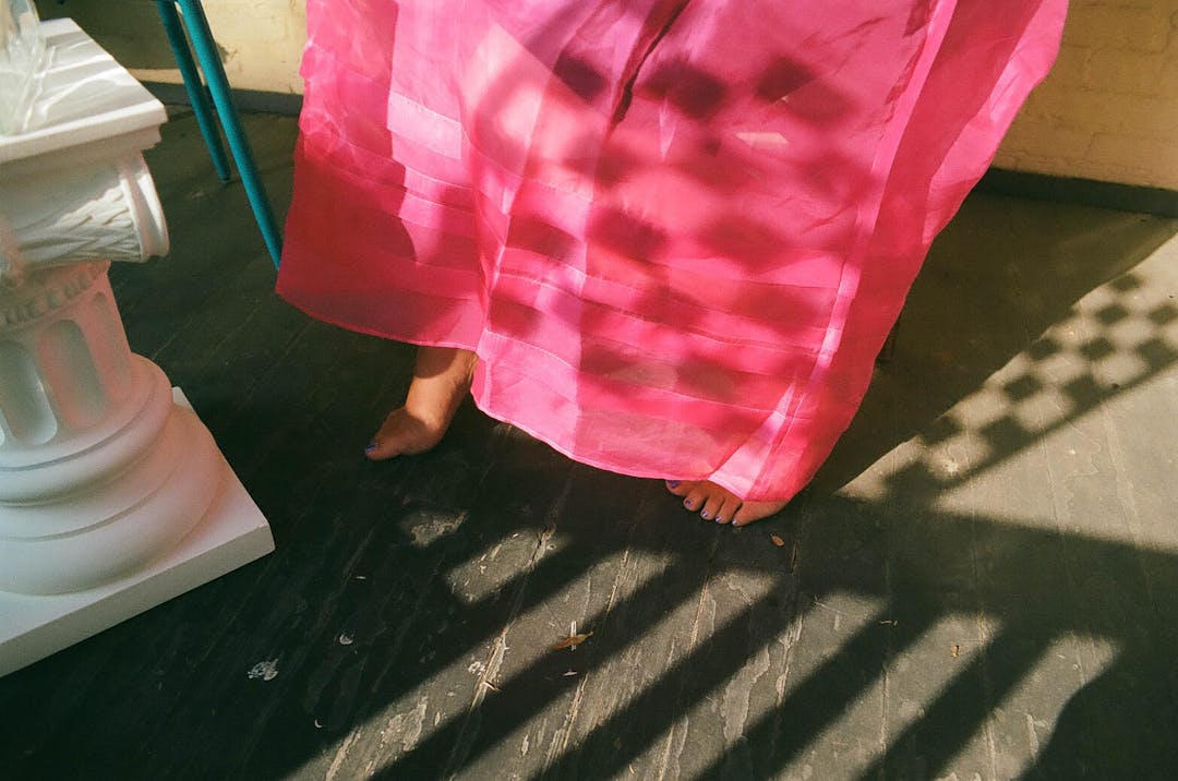 color film photo of checkerboard pattern shadow on pink dress