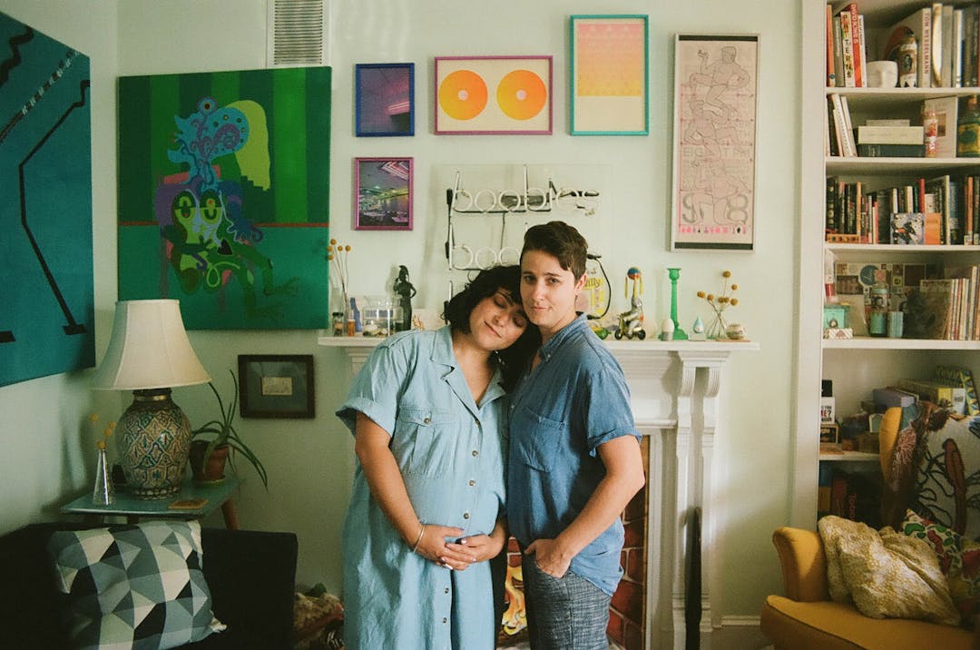 color film photo of couple standing in colorful and art-ful livingroom 
