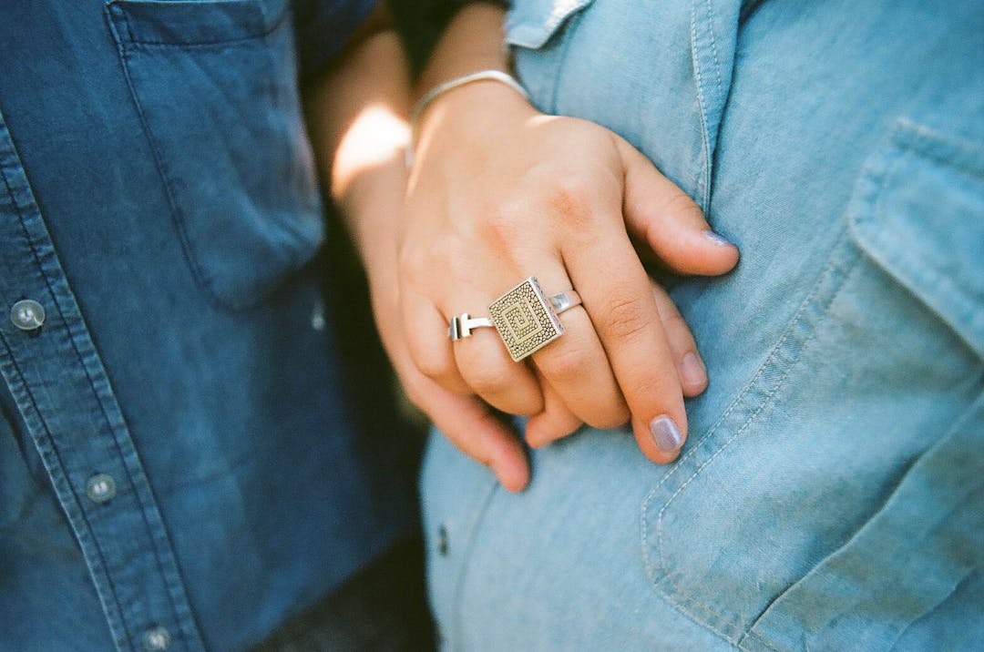 color photo of two woman in blue denim holding hands
